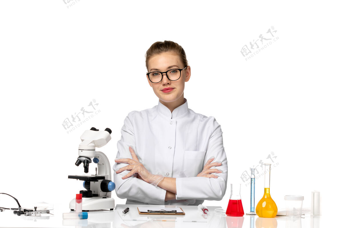 桌子前视图穿着白色医疗服的女医生坐在桌子前面 白色空间上有解决方案坐着修理工疾病