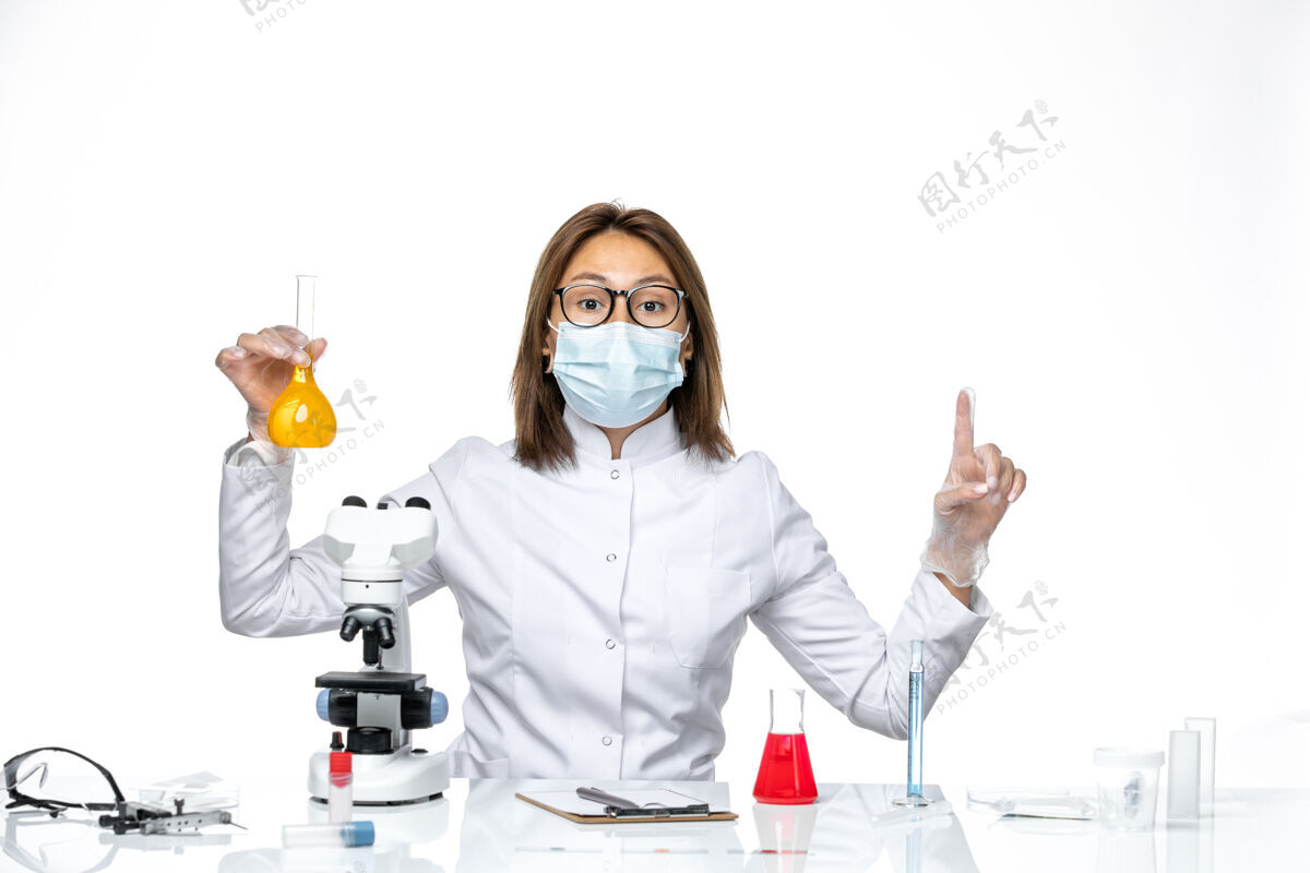 实验室外套前视图女医生穿着白色医疗服 戴着口罩 由于冠状病毒正在用白色地板病毒的解决方案进行大流行隔离病毒工作口罩