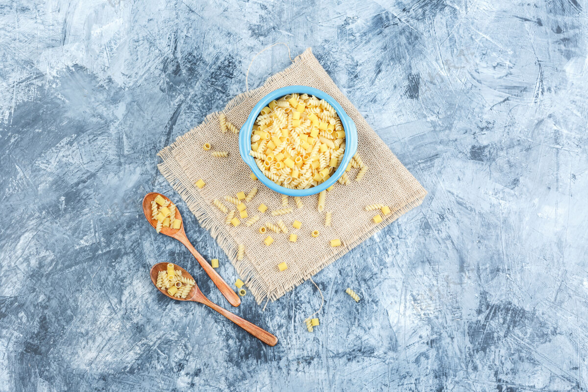 博洛尼亚生面食放在碗里 木勺放在灰泥上 布袋背景顶视图奶酪石膏素食者