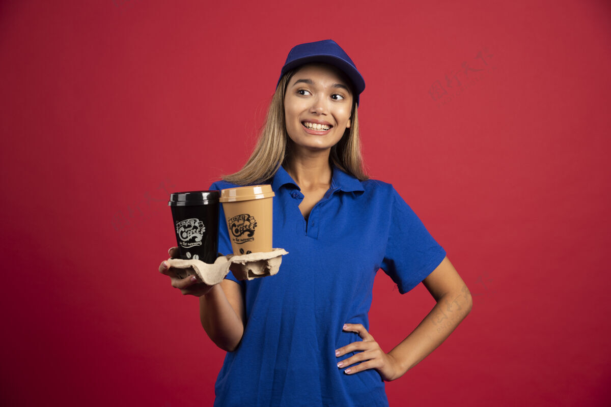 女士穿蓝色制服的年轻女子给了一盒两个杯子制服女士帽子
