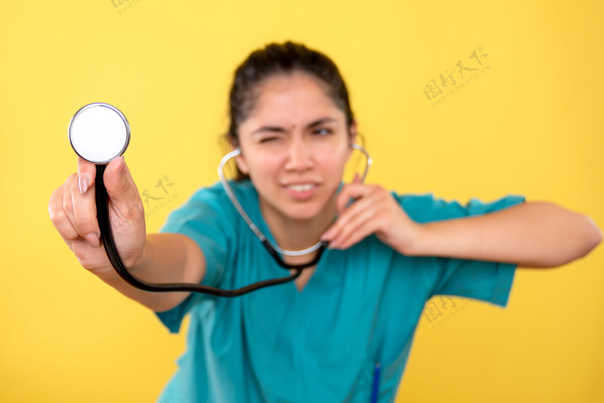 医生黄色隔离墙上女医生手上听诊器的正视图成人正面人