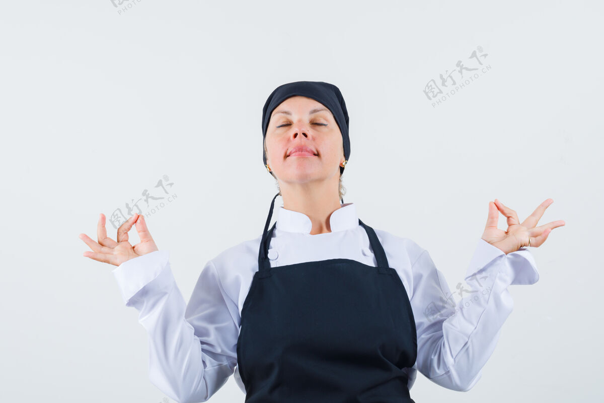 肖像女厨师穿着制服 围裙 表情轻松 展示冥想姿势前视图手自信欢呼