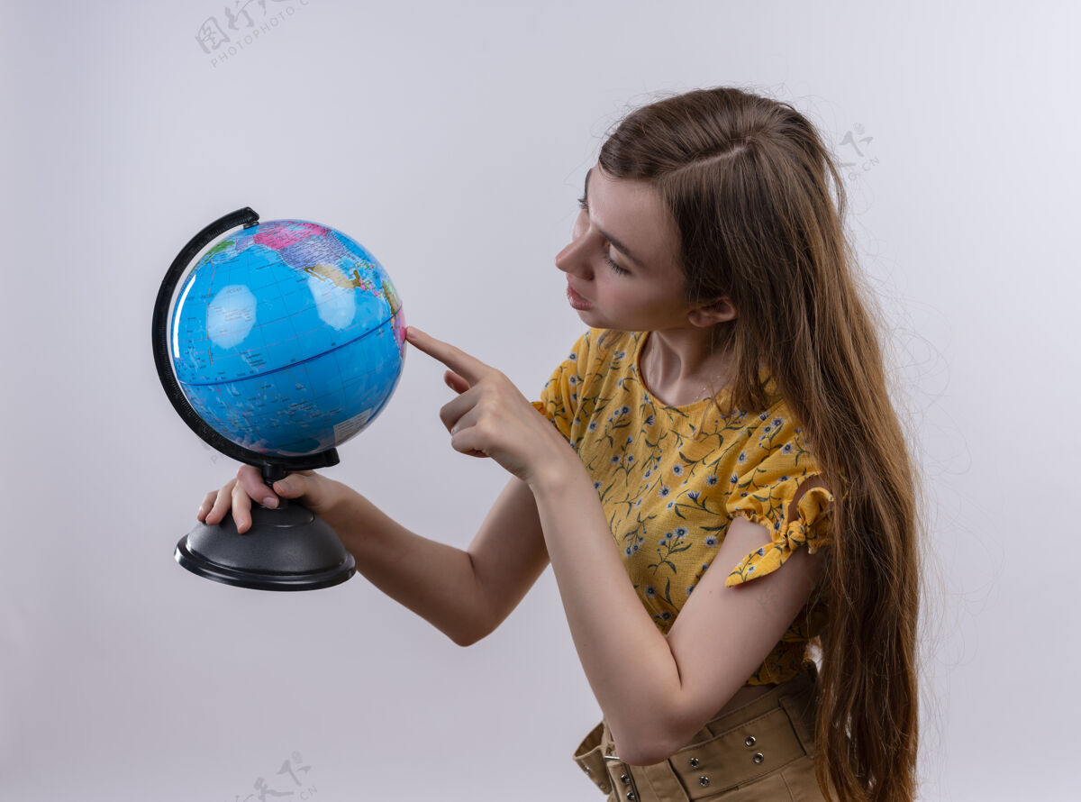 指着一个年轻女孩拿着地球仪 在孤零零的白墙上看着它女孩拿着年轻