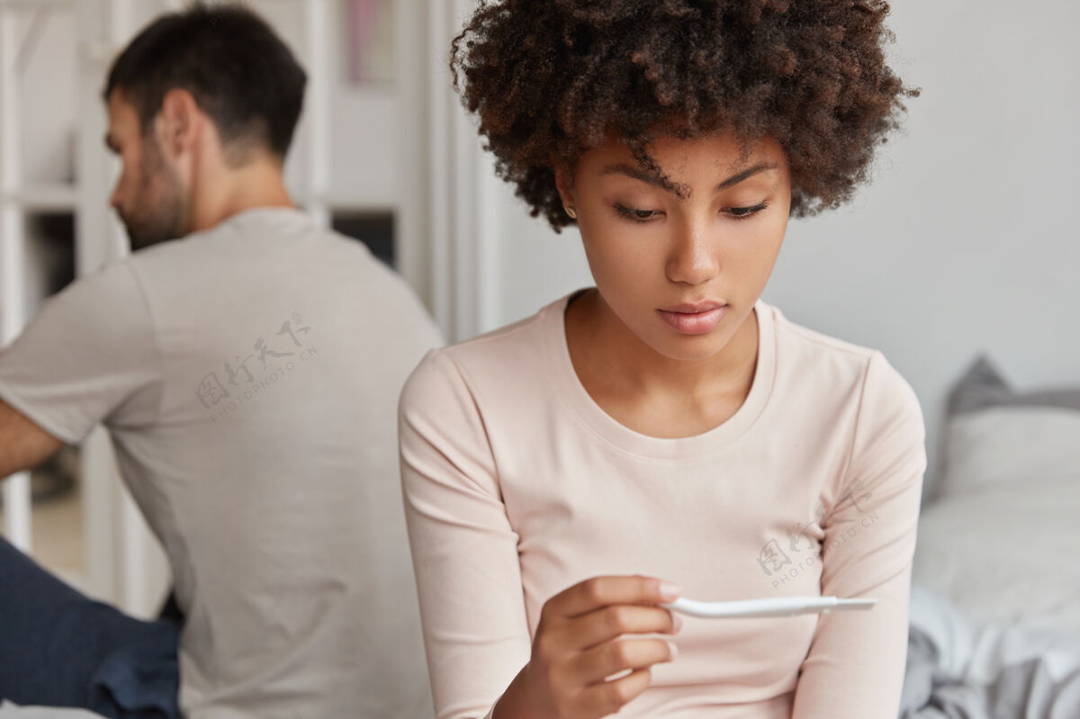 女性严肃的黑皮肤女性专心看怀孕测试拍摄悲伤测试