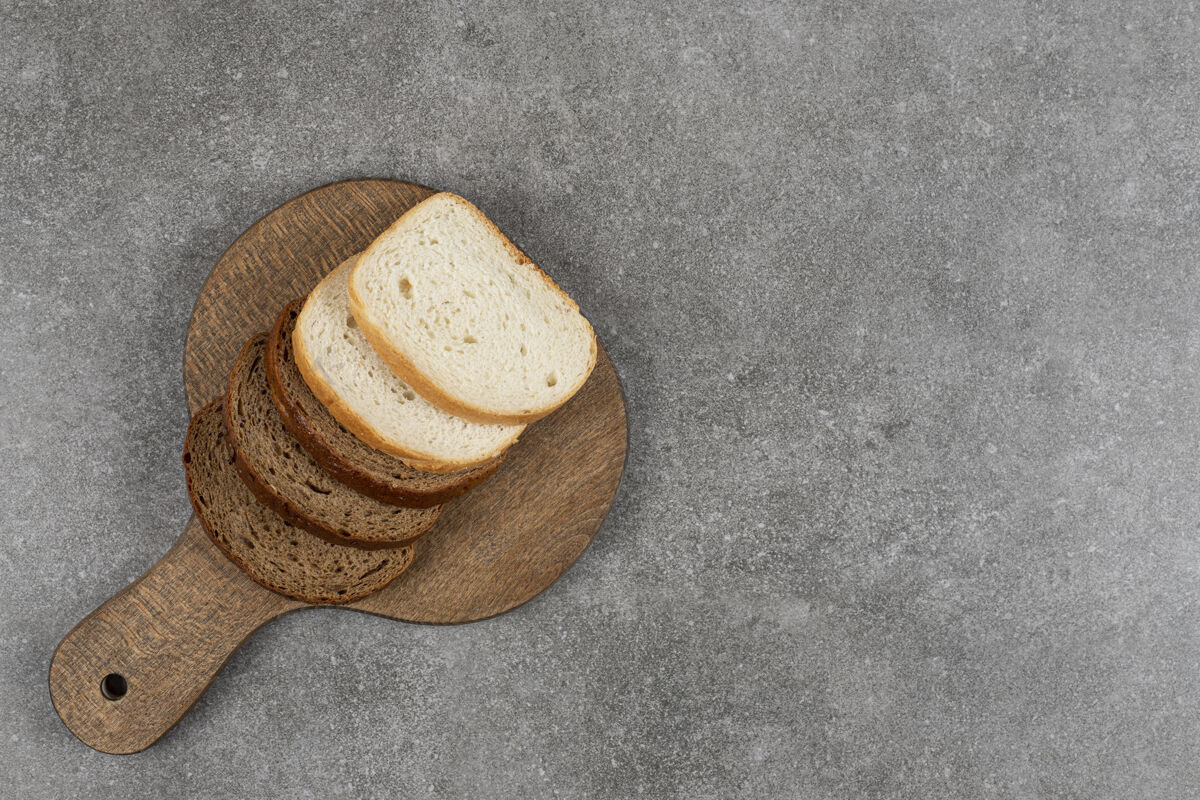 美味把黑面包和白面包片放在木板里糕点面包食品