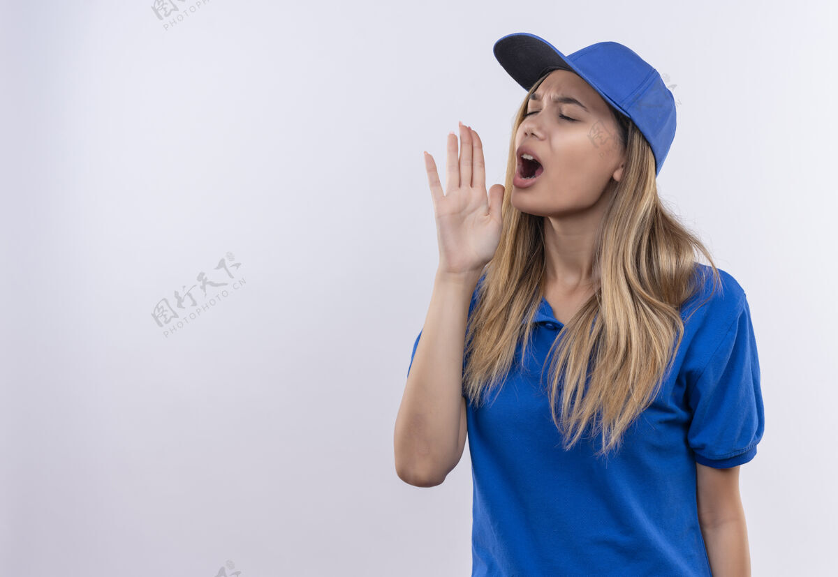 关门一个穿着蓝色制服 戴着帽子 闭着眼睛的年轻送货女孩 在白色的墙上喊着一个孤立的人 留着复印空间制服女孩年轻