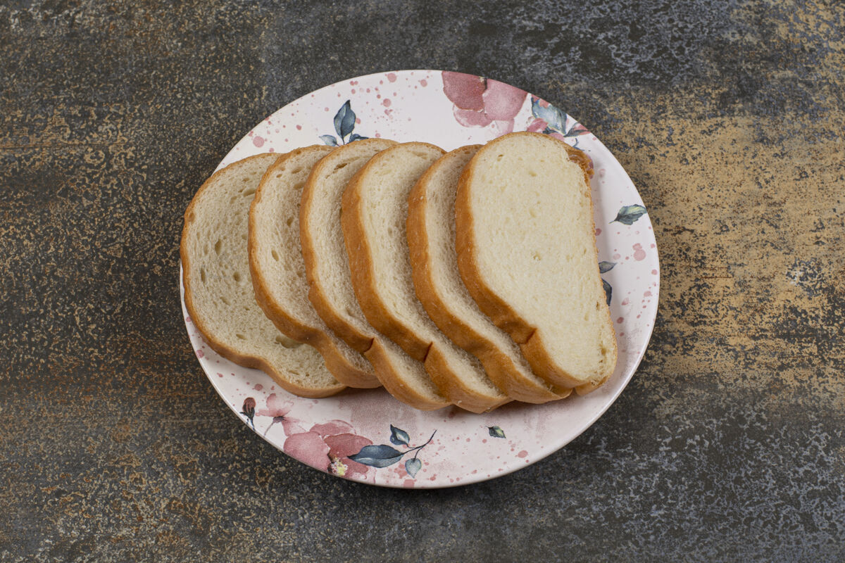 一餐美味的白面包片放在五颜六色的盘子里有机美味切片