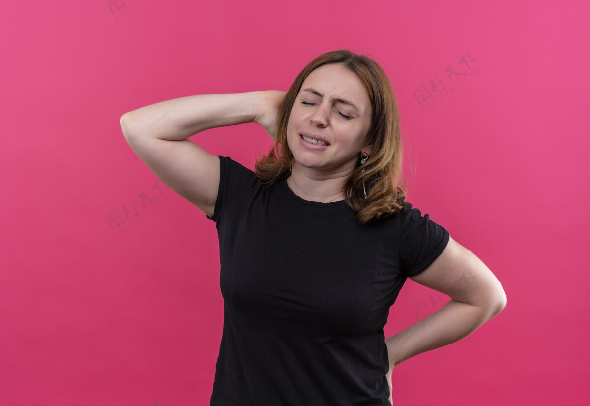 手紧张的年轻休闲女人 双手放在脑后 背对着孤立的粉色墙壁压力背部年轻
