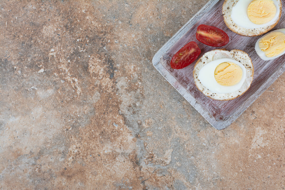 食品在木板上放上煮鸡蛋和西红柿片的面包片吐司面包鸡蛋