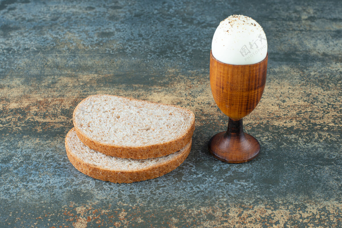 蛋黄在大理石背景上煮的面包片一餐切片食物