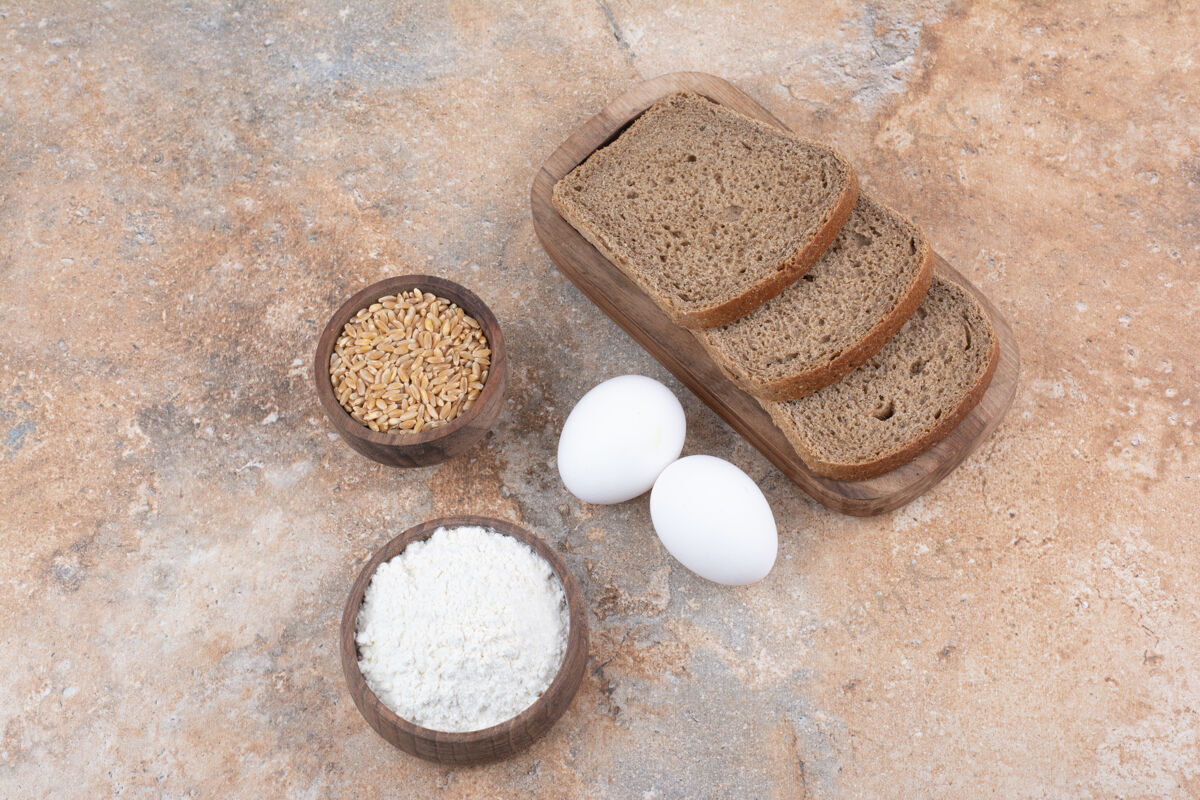 自制黑面包片 面粉 大麦和鸡蛋放在大理石表面碗谷类面粉