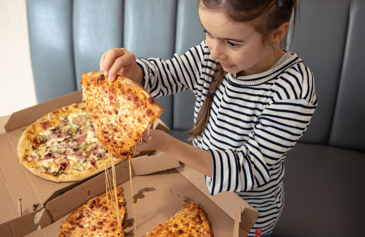 新鲜小女孩午餐吃开胃的奶酪披萨比萨饼食物特写