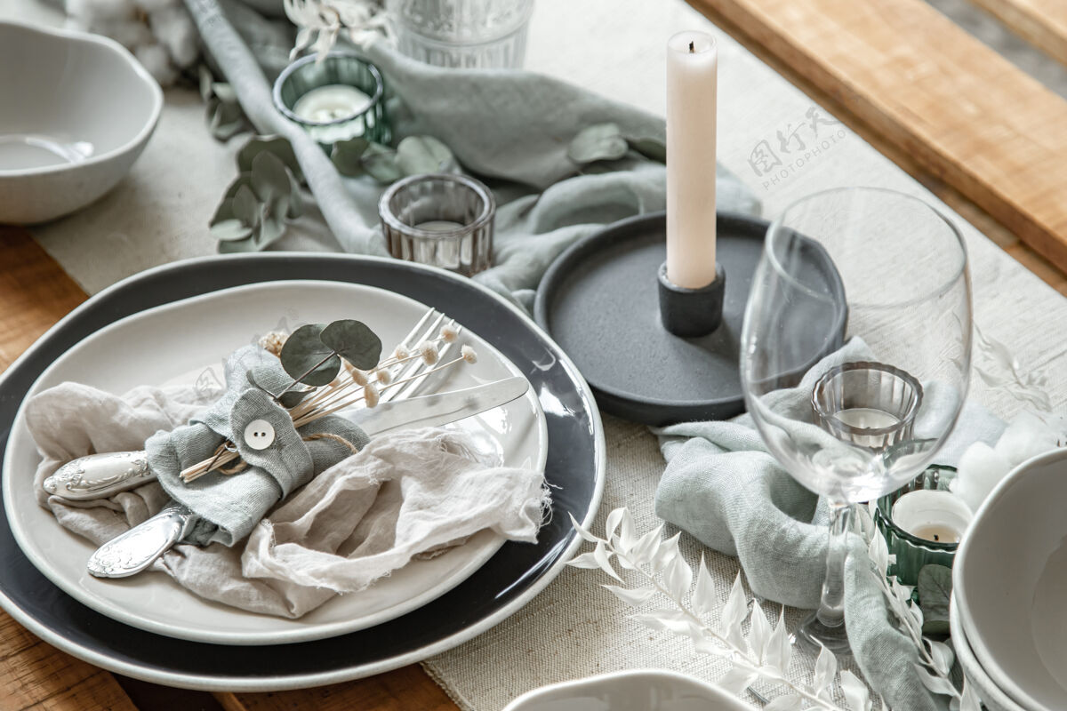 干洗节日餐桌的特写细节 包括一套餐具 一个盘子和烛台上的蜡烛蜡烛衣服鲜花