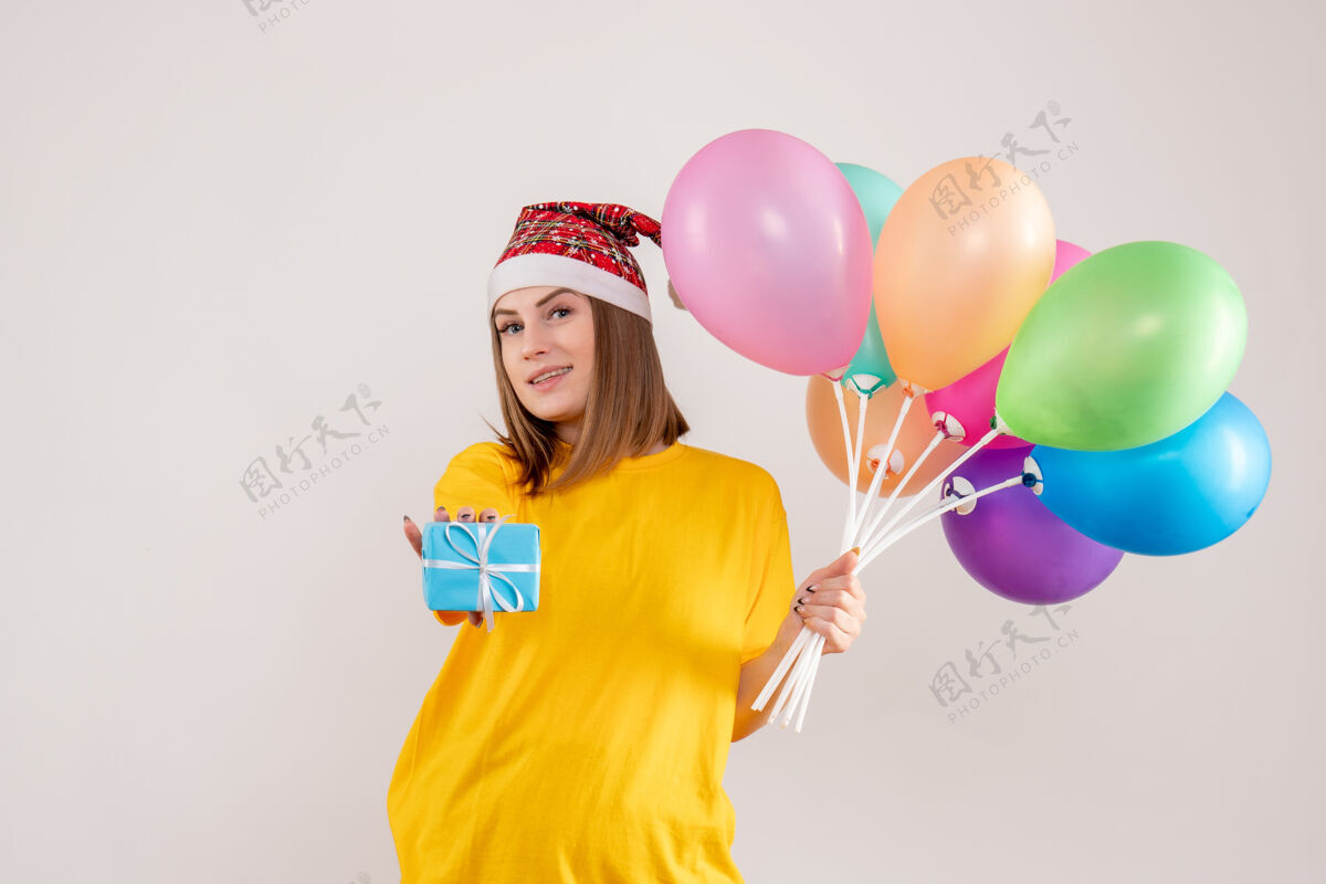 乐趣手持小礼物和白色气球的年轻女性庆祝礼物生日