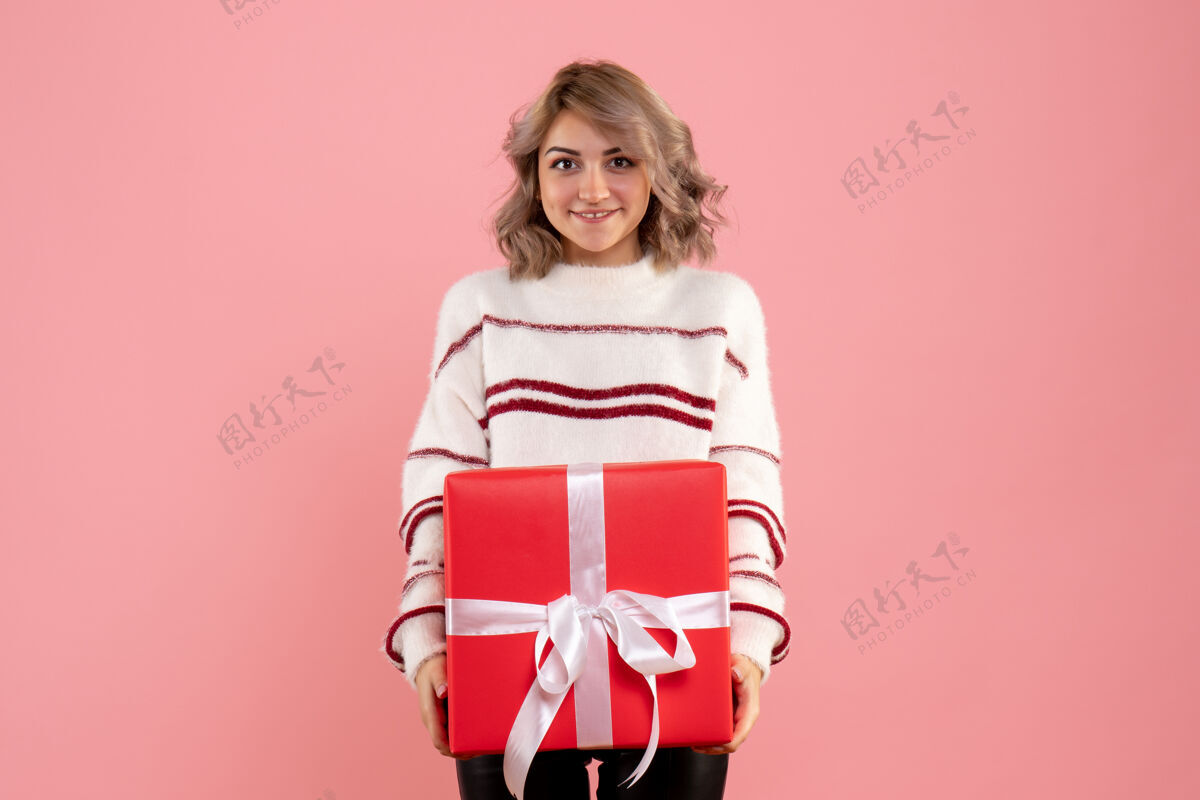 衣服年轻的女性高高兴兴地拿着粉红色的圣诞礼物女人风景快乐