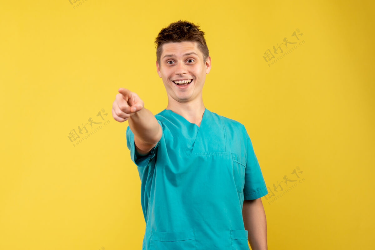 背景正面图黄色背景上穿着医疗服的年轻男医生年轻男性医生人医学