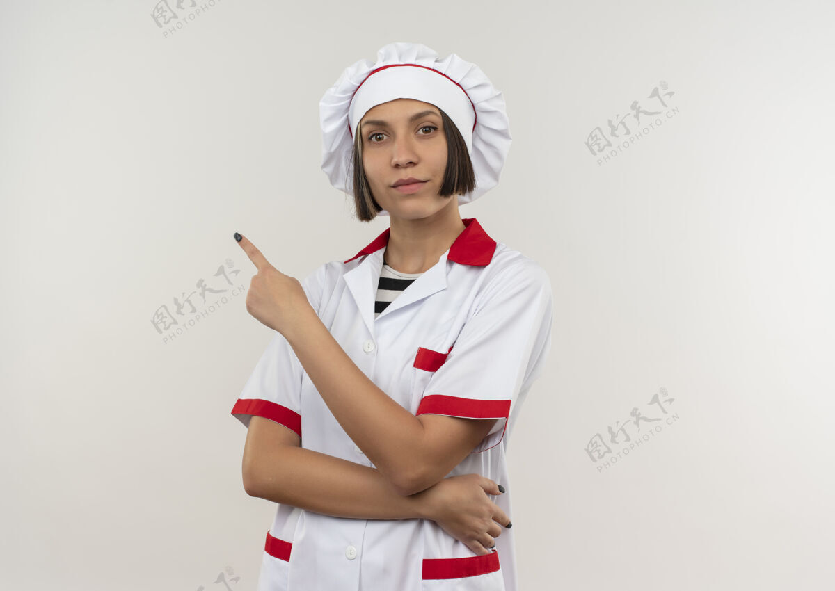 年轻自信的年轻女厨师 身着厨师制服 指着隔离在白色地板上的一侧 留有复印空间复制女性烹饪