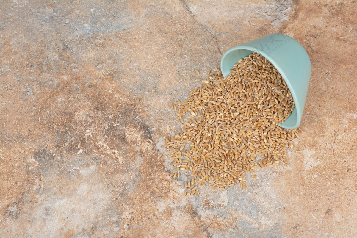 谷类大麦粒从碗里出来放在大理石表面堆堆自然