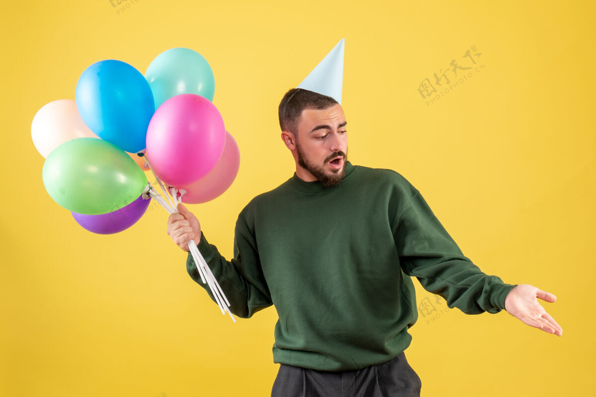 年轻的男性正面图黄色气球上的年轻男性快乐乐趣聚会