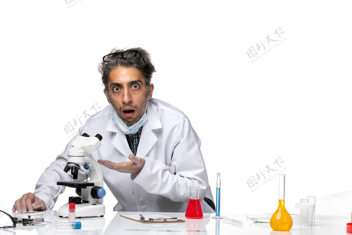 特殊前视图中年科学家穿着特殊的白色西装使用显微镜实验室化学外套