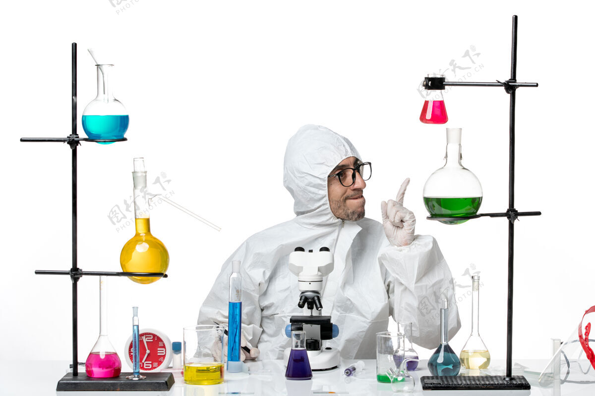 保护正面图穿着特殊防护服的男科学家拿着钢笔坐着实验室实验室实验