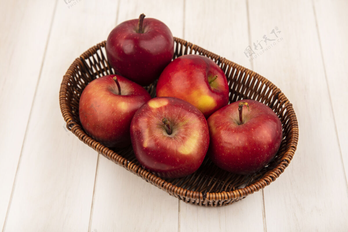 特写白色木墙上的桶上新鲜的红苹果的俯视图农业景观新鲜