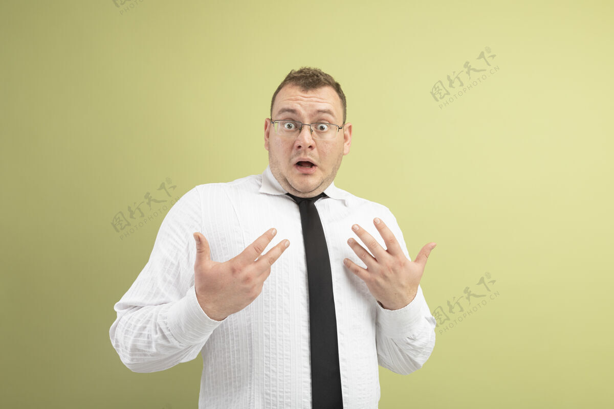 复制令人印象深刻的成年斯拉夫男子戴着眼镜 打着领带 看着摄像机指着自己 双手孤立地放在橄榄绿的背景上 留有复印空间空间印象领带