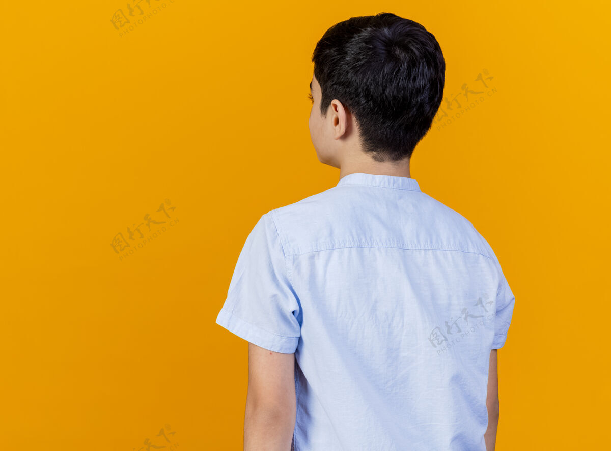 复制年轻的白人男孩站在后面的看法孤立的橙色背景与复制空间橙色空间年轻