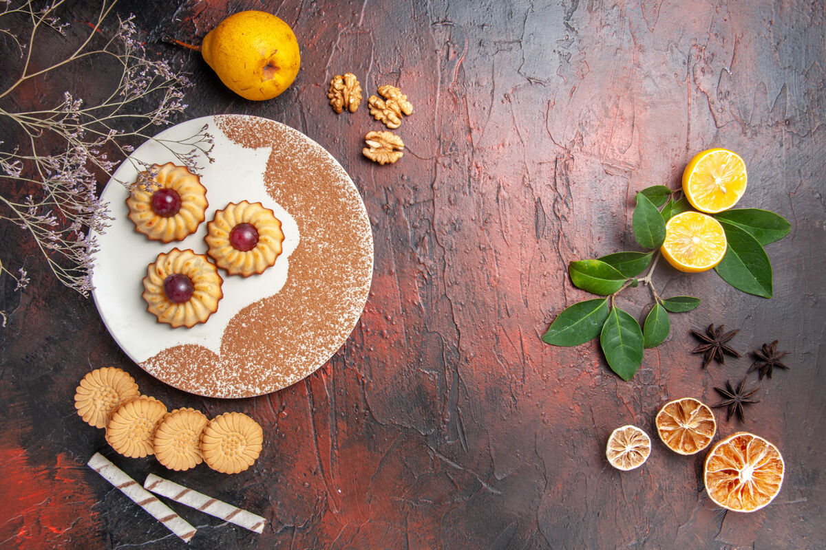 食物俯视图美味的小饼干与水果在黑暗的桌子蛋糕甜饼干糖深色水果健康