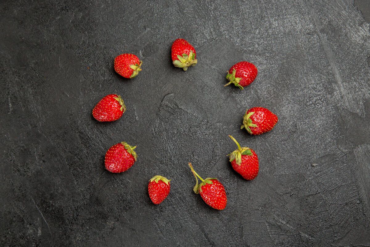 深色顶视图新鲜的红色草莓衬在深色的餐桌上 颜色是成熟的水果浆果背景草莓图钉