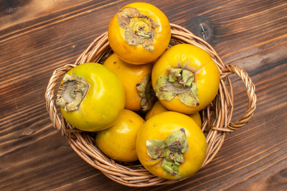 柿子顶视图新鲜柿子熟了甜甜的果实上 棕色的桌上果实醇厚成熟成熟食物水果