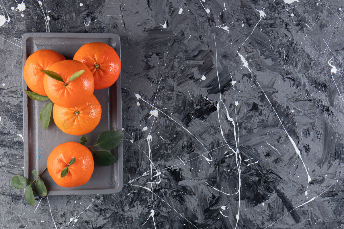 自然把新鲜的橘子放在木盘上 放在混合桌上橘子美味营养