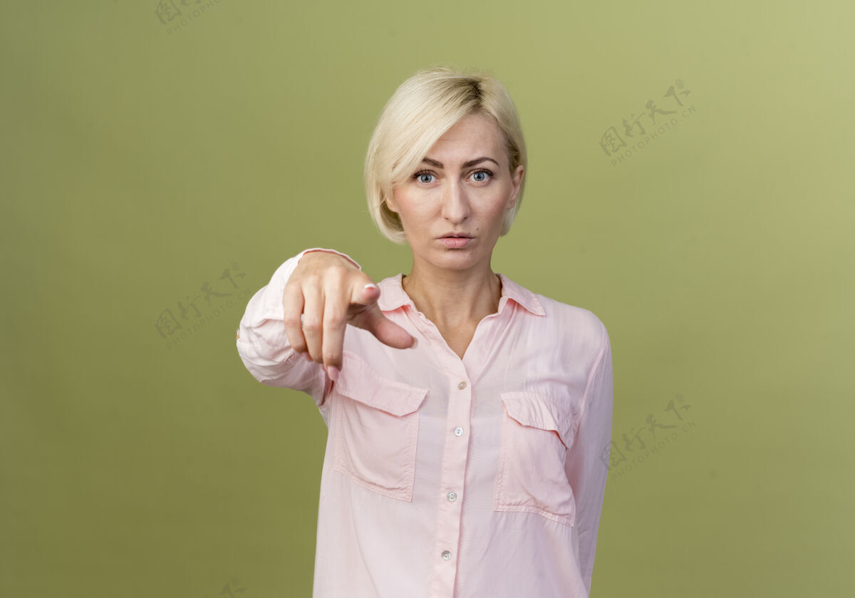 手势自信的年轻金发斯拉夫女人在橄榄绿的墙上向你展示孤立的姿态斯拉夫金发女人