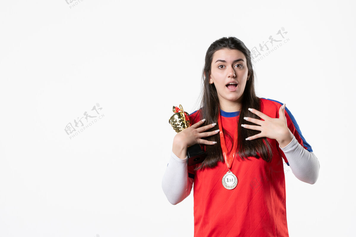 白色前视图穿着运动服的女运动员 拿着奖牌和金杯体育奖杯球员