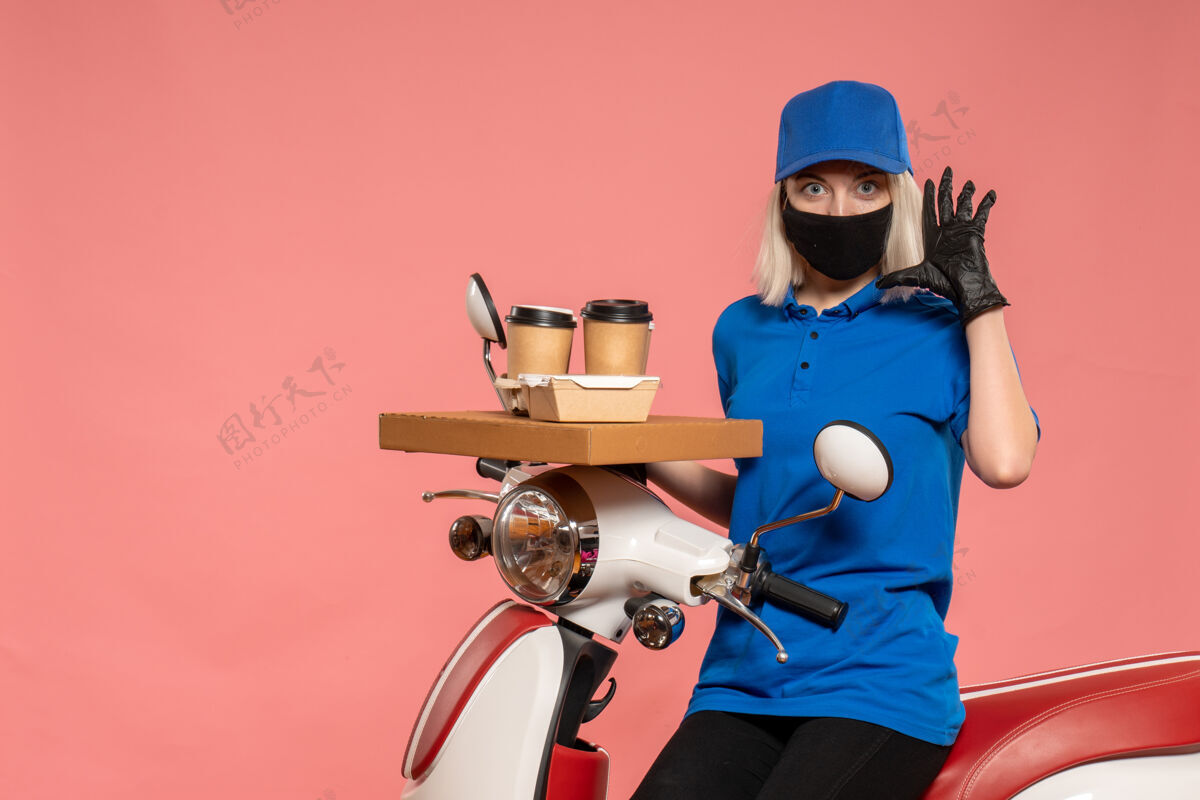 自行车正面图骑自行车的女快递员 咖啡杯是粉红色的咖啡流行病女信使