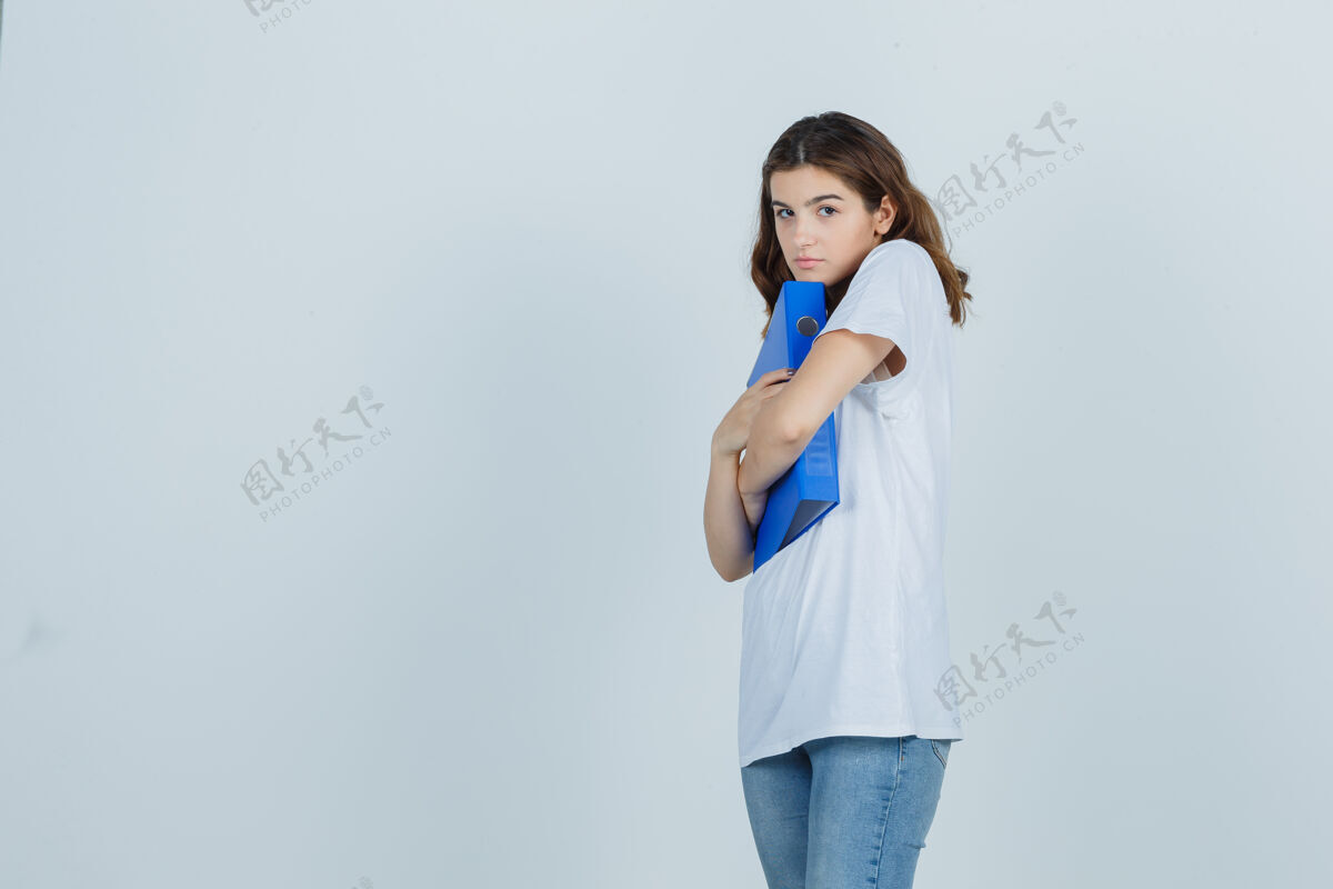 积极穿着白色t恤的年轻女孩抱着文件夹 看上去很尴尬 正面照微笑护理女人