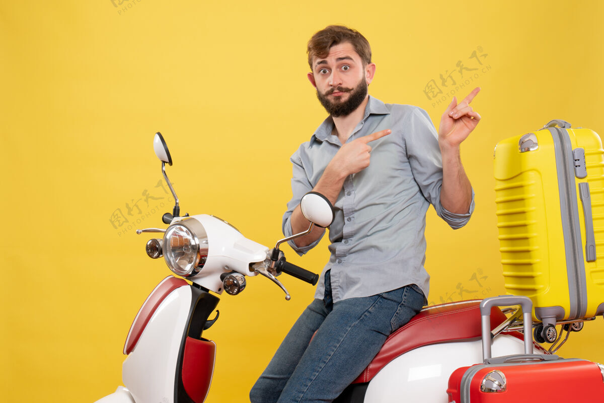 自行车旅游概念与年轻的情感胡须男子坐在摩托车上指向黄色的背面摩托车背部轻便摩托车