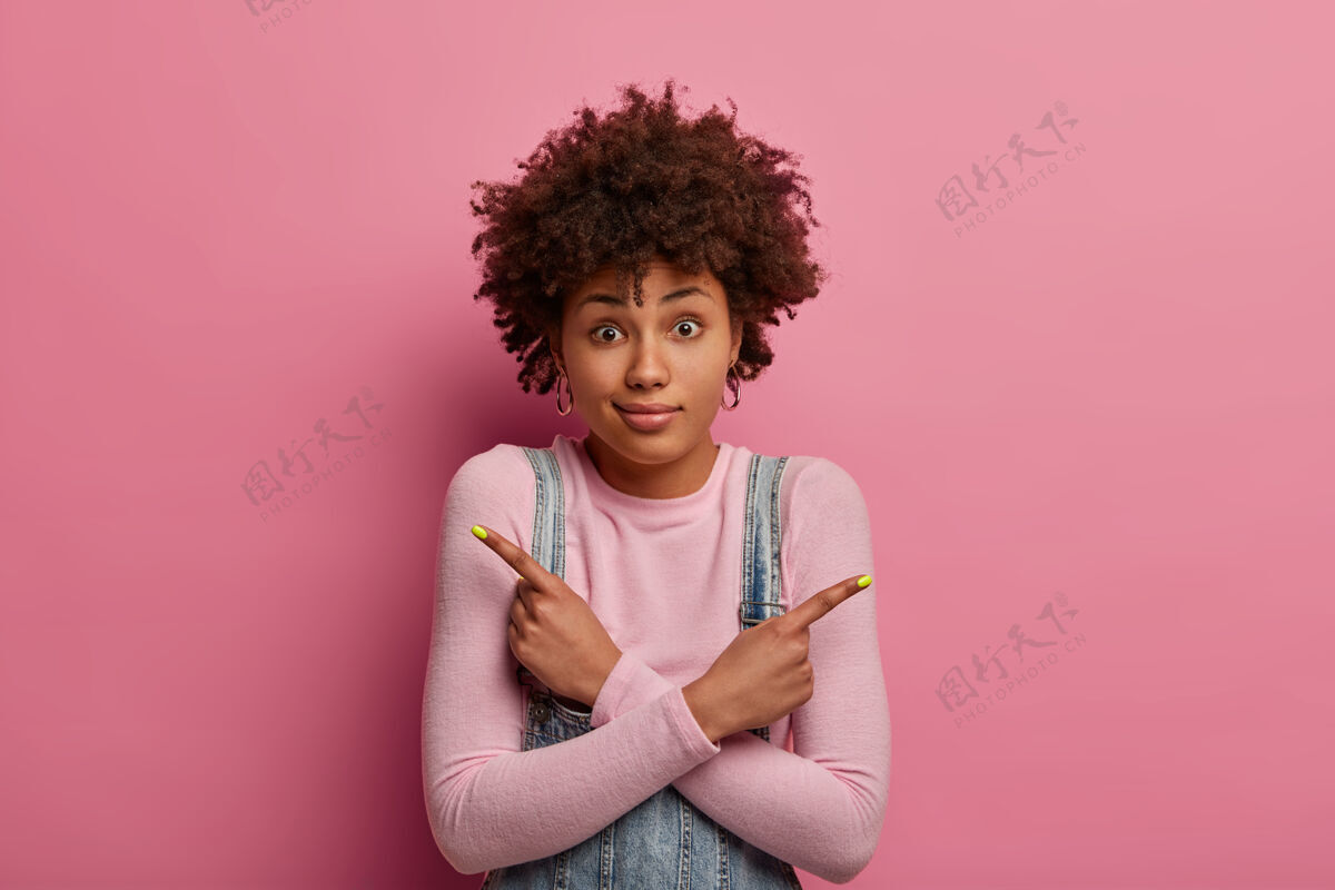 自然犹豫不决的黑发女人想点什么 双臂交叉在身上 侧指 穿高领毛衣 惊讶地凝视着 试图做出选择 显示出两个变种选项墙站