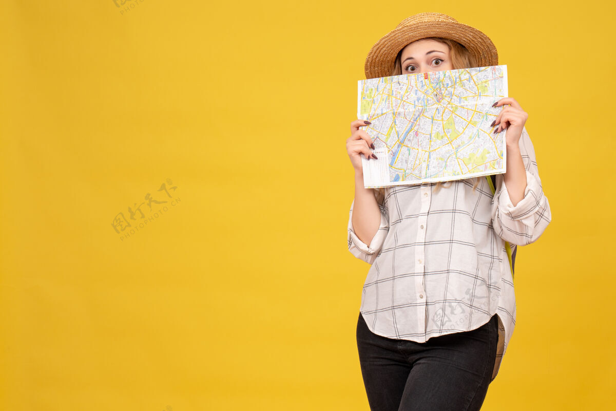 背包顶视图微笑的旅行女孩戴着她的帽子和背包举行黄色地图微笑漂亮上衣