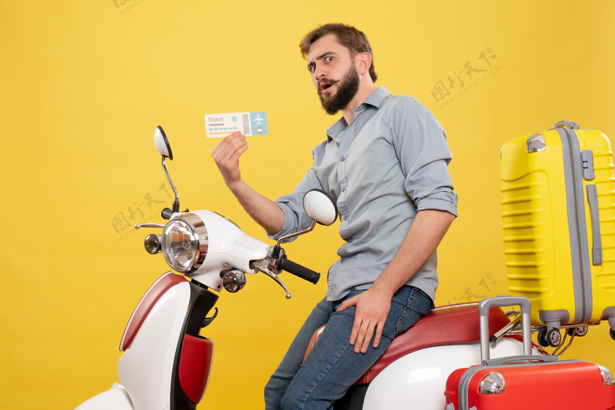 车旅游概念的正面图 留着胡子的年轻人坐在摩托车上 手提箱上挂着黄色的车票手提箱成人人