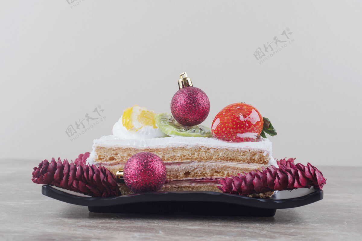 节日蛋糕片放在盘子上 用大理石装饰节日的装饰品美味烘焙拼盘