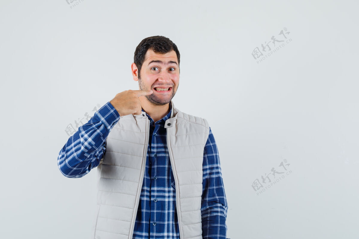 男人年轻男子指着自己的牙齿在衬衫 无袖夹克前视图自信手虚拟