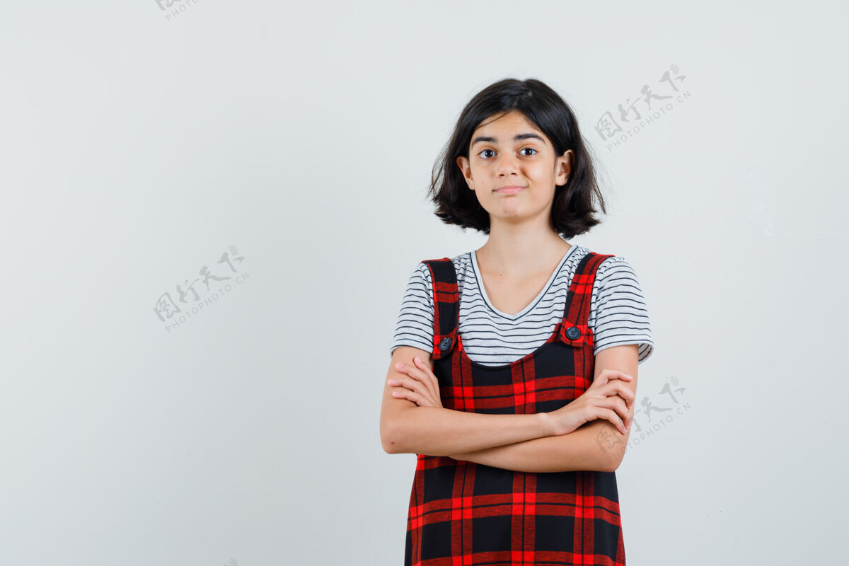 休闲穿t恤 连身衣 双臂交叉站立的未成年女孩 看上去很高兴正面图自信女性时髦