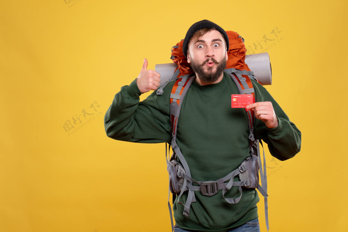 好旅行理念 自信的年轻人 背着背包 拿着银行卡 在黄色上做出ok手势扩音器制造银行