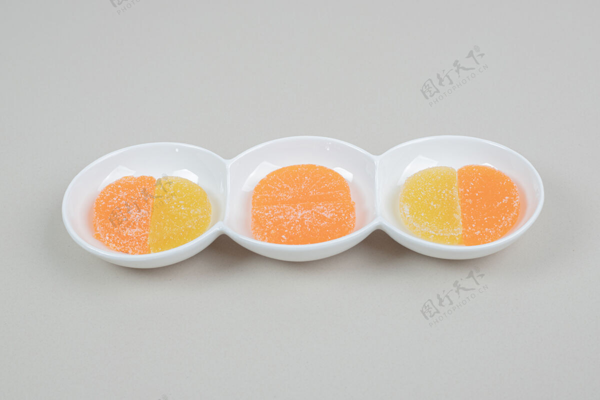 切片白色盘子上有两个彩色果冻糖果酱五颜六色零食