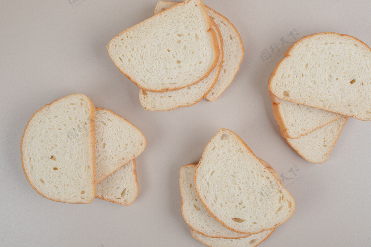 营养把新鲜的白面包片放在白色的表面上糕点皮美味