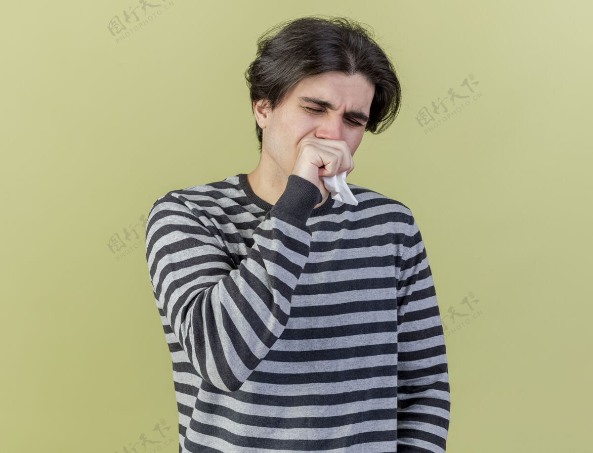 嘴闭上眼睛 年轻的病人拿着餐巾 手放在嘴上 隔离在橄榄绿的背景上闭着年轻餐巾