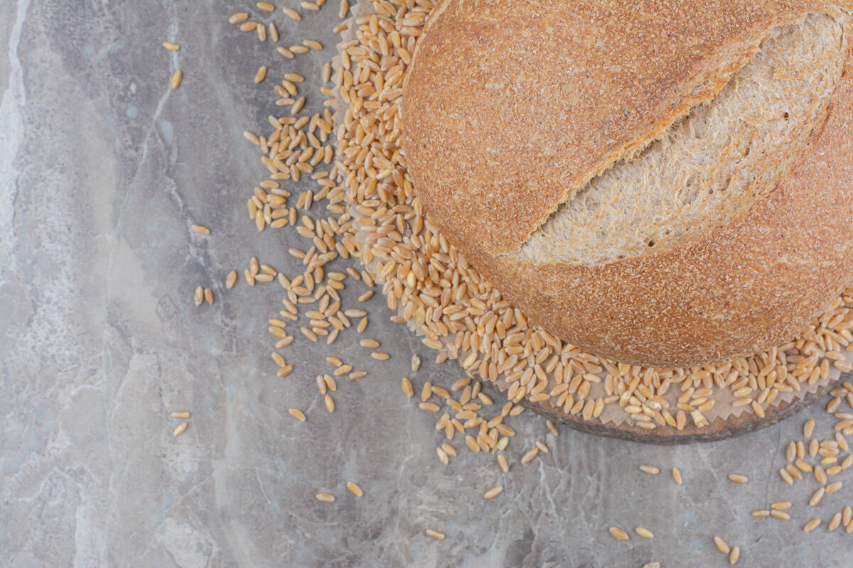 谷类未煮的燕麦和面包放在大理石表面膳食燕麦美味