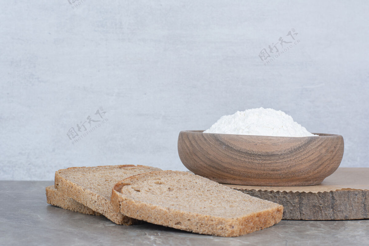 面包在大理石表面用面粉做的棕色面包片切片美味膳食