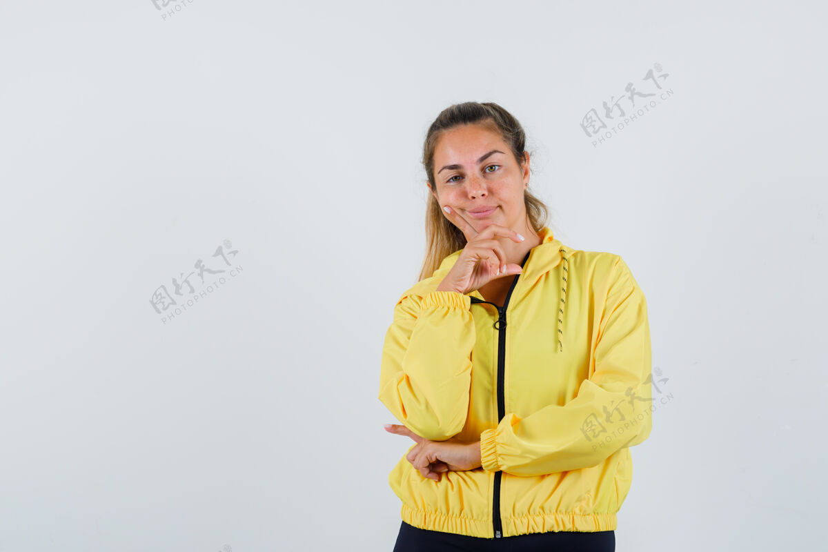 厨房一个穿着黄色雨衣的年轻女子斜靠着她的手指看着前面 看上去很乏味女人早晨前面